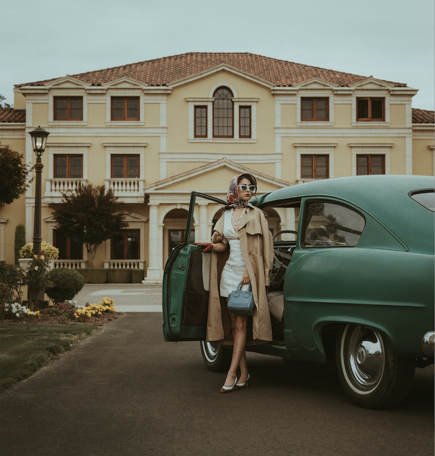 lady in front of car at a mansion in italy looking luxurious and designer clothes